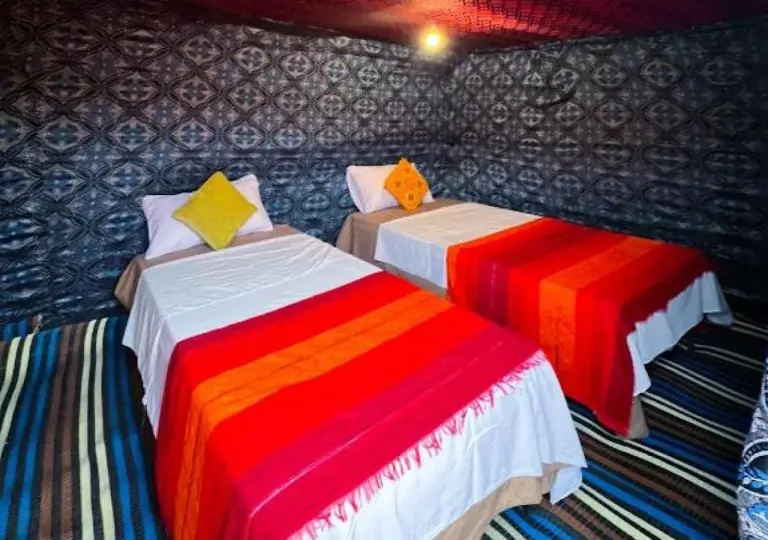 Moroccan Desert Camp in Merzouga twin guest room inside a decorated desert tent