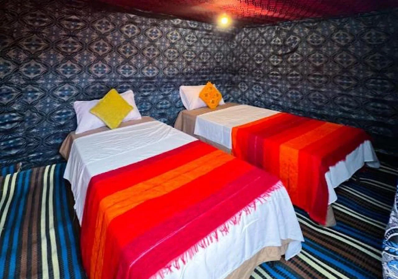 Moroccan Desert Camp in Merzouga twin guest room inside a decorated desert tent