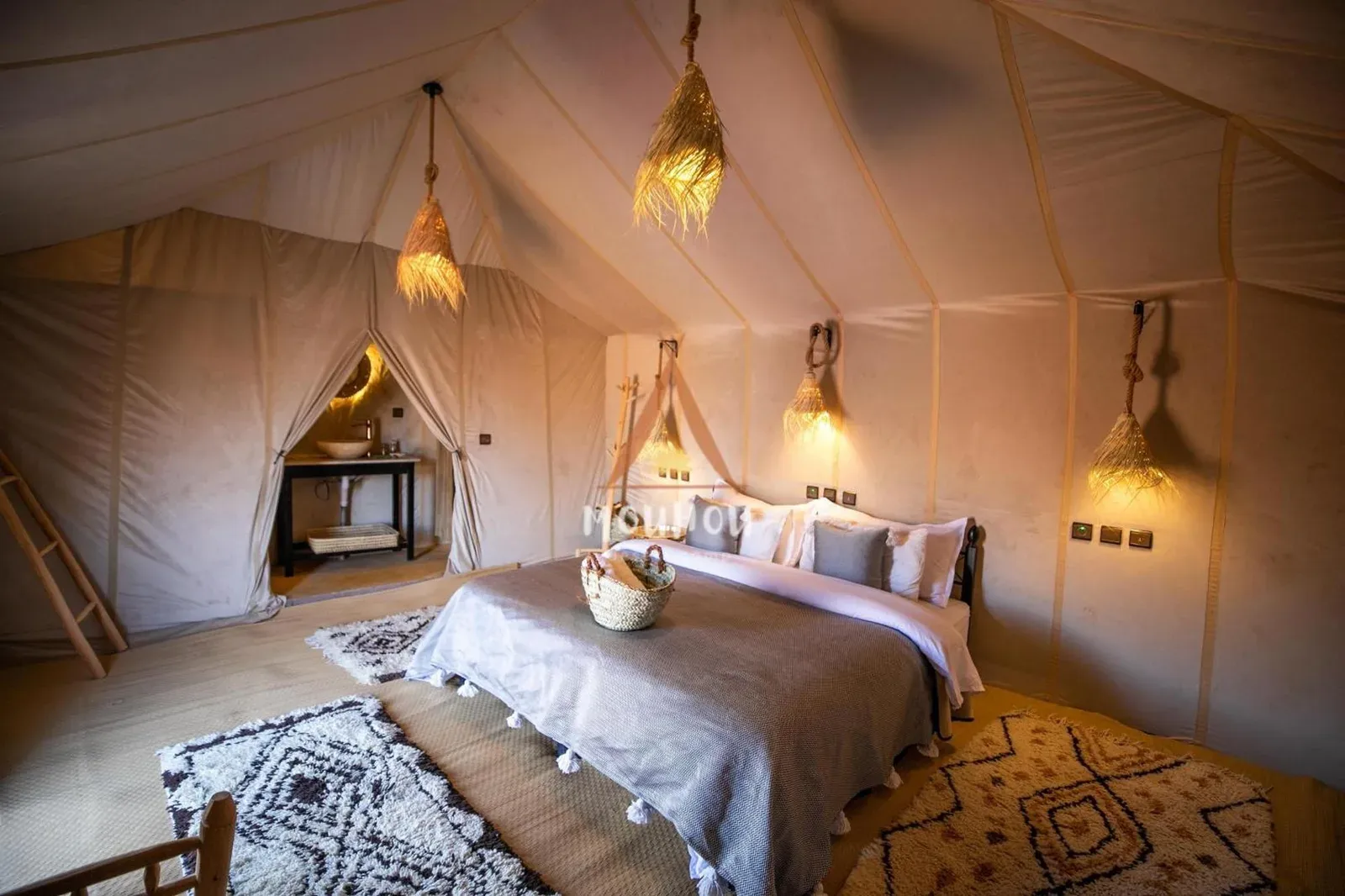 Elegante dormitorio king dentro de Mouhou Desert Camp en Merzouga con decoración de estilo desértico