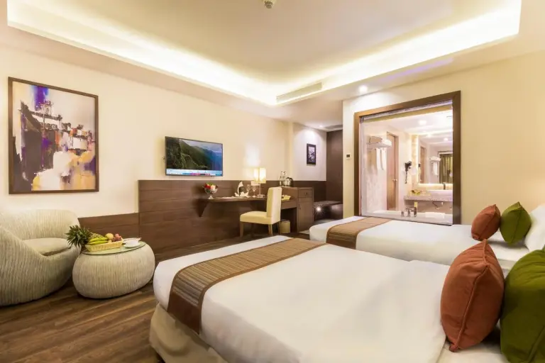 Chambre twin au Mountain Glory Forest Resort and Spa, Pokhara avec deux lits, un coin salon et une vue depuis le balcon.