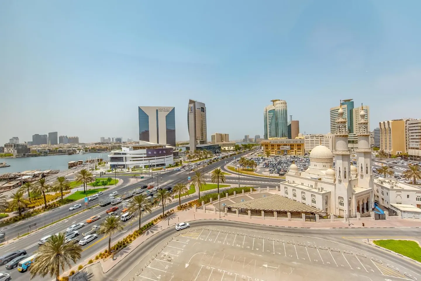 Large vue panoramique depuis le Mövenpick Dubai Creek à Dubai montrant le creek, la skyline et la circulation en contrebas.