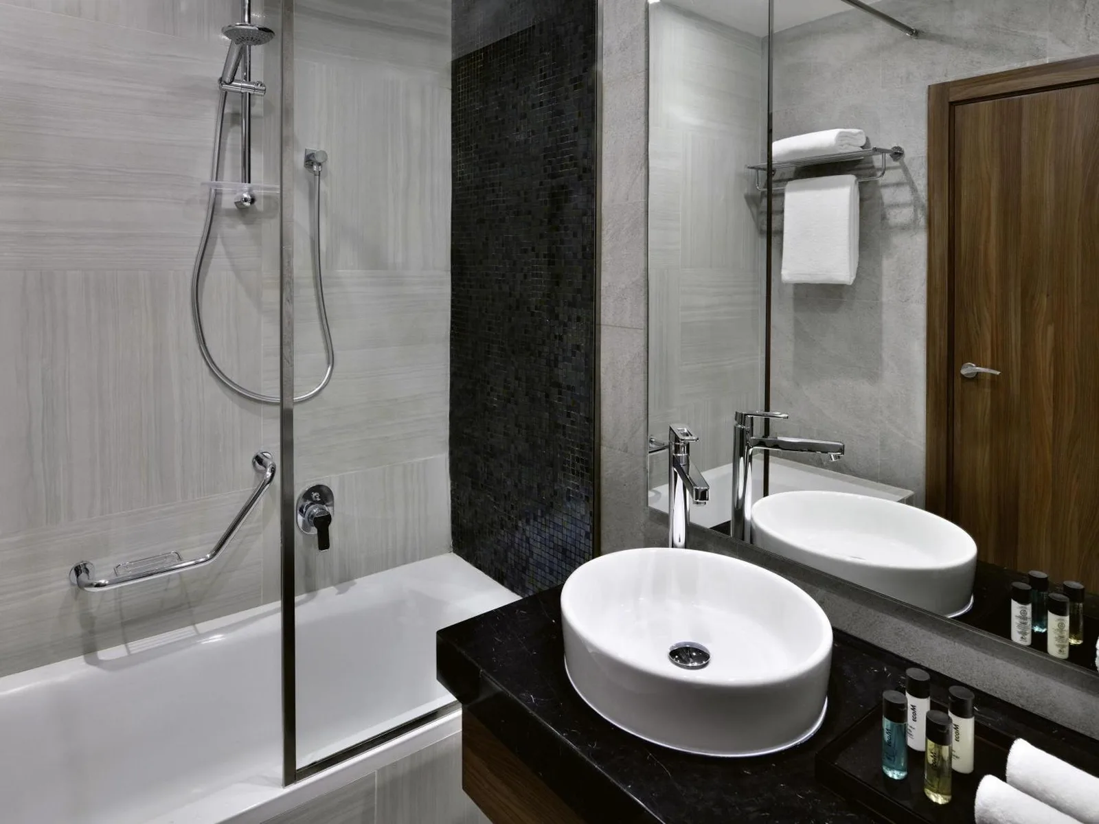 Mövenpick Hotel Apartments Downtown Dubai – hotel en Dubái, Emiratos Árabes Unidos – un baño con un lavabo, una ducha y una bañera en Mövenpick Hotel Apartments Downtown Dubai en Dubái