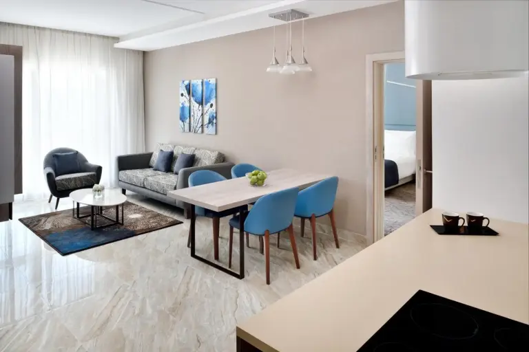 Mövenpick Hotel Apartments Downtown Dubai – hotel en Dubái, Emiratos Árabes Unidos – una sala de estar con una mesa y sillas azules en Mövenpick Hotel Apartments Downtown Dubai en Dubái