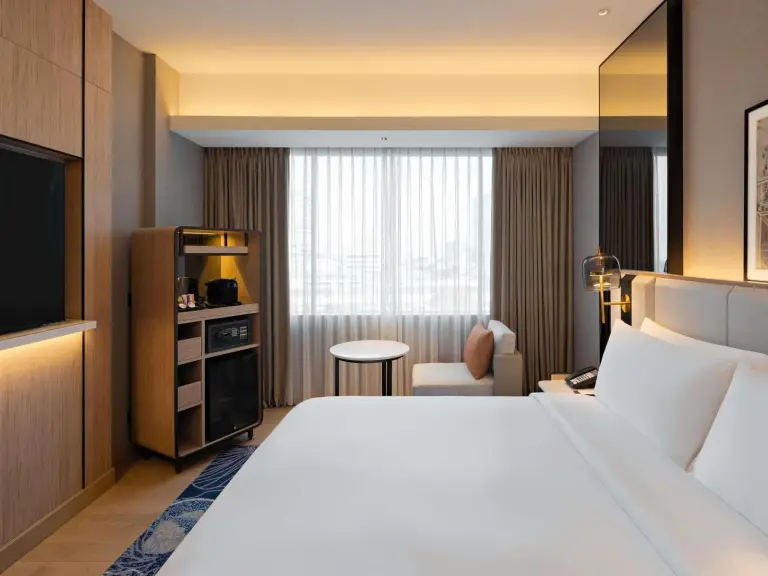 Mövenpick Hotel Jakarta City Centre – hotel de Jakarta, Indonesia – un dormitorio con una gran cama blanca y un televisor de pantalla plana en Mövenpick Hotel Jakarta City Centre en Jakarta