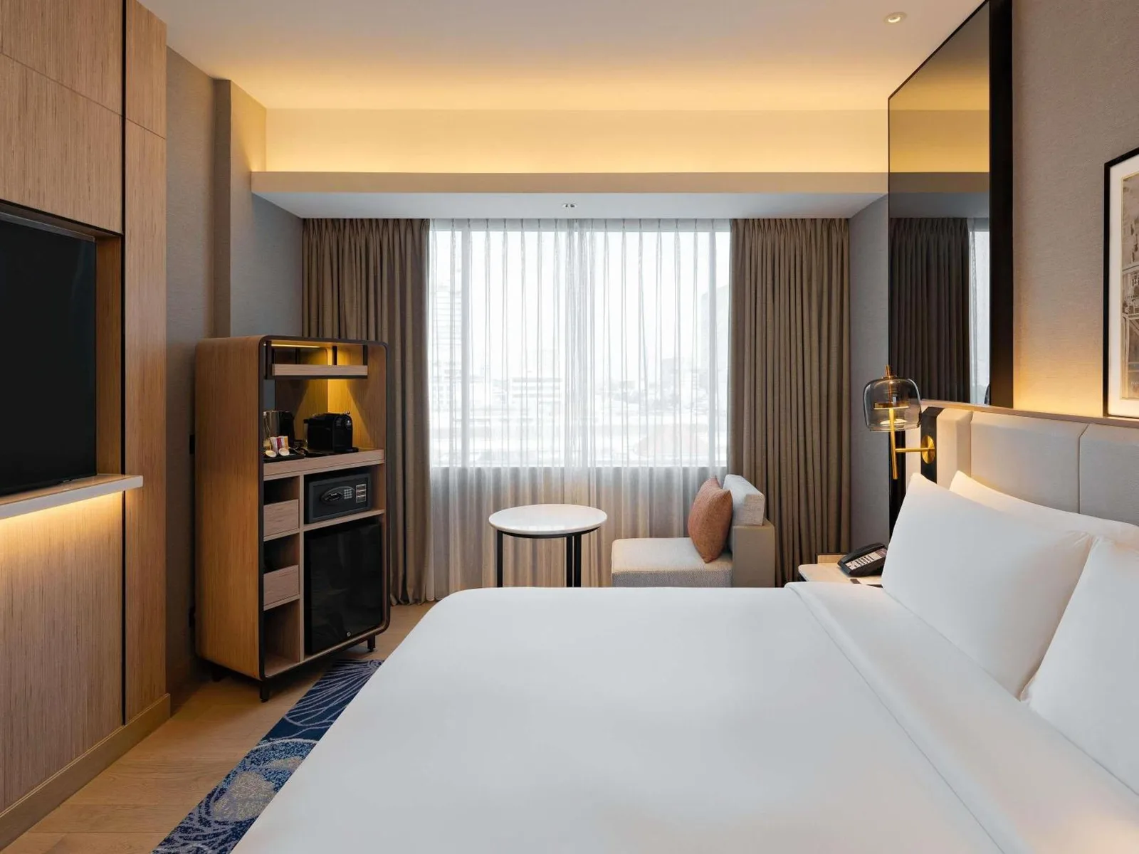 Mövenpick Hotel Jakarta City Centre – hotel de Jakarta, Indonesia – un dormitorio con una gran cama blanca y un televisor de pantalla plana en Mövenpick Hotel Jakarta City Centre en Jakarta