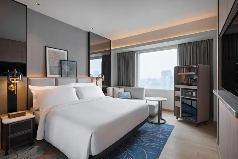 Mövenpick Hotel Jakarta City Centre – hotel de Jakarta, Indonesia – un dormitorio con una gran cama blanca y una ventana en Mövenpick Hotel Jakarta City Centre en Jakarta