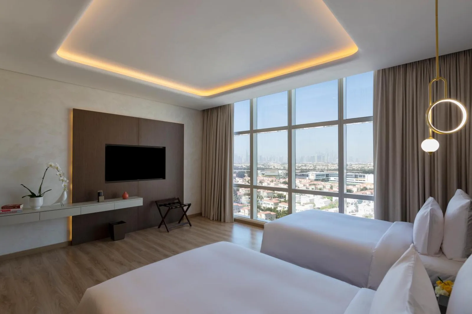 Movenpick Jumeirah Village Triangle – Hotel in Dubai, Vereinigte Arabische Emirate – ein Hotelzimmer mit einem Bett und einem großen Fenster im Movenpick Jumeirah Village Triangle in Dubai