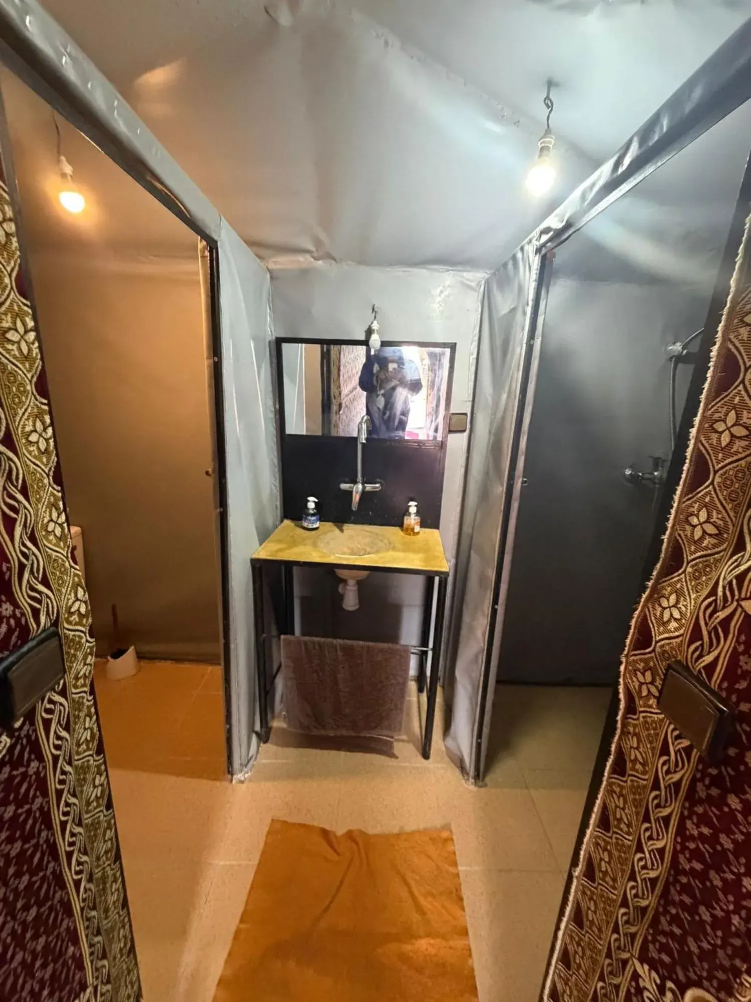 Waschbereich im Badezimmer des Mustapha Camp Merzouga mit Spiegel und Waschbecken in einem Zelt