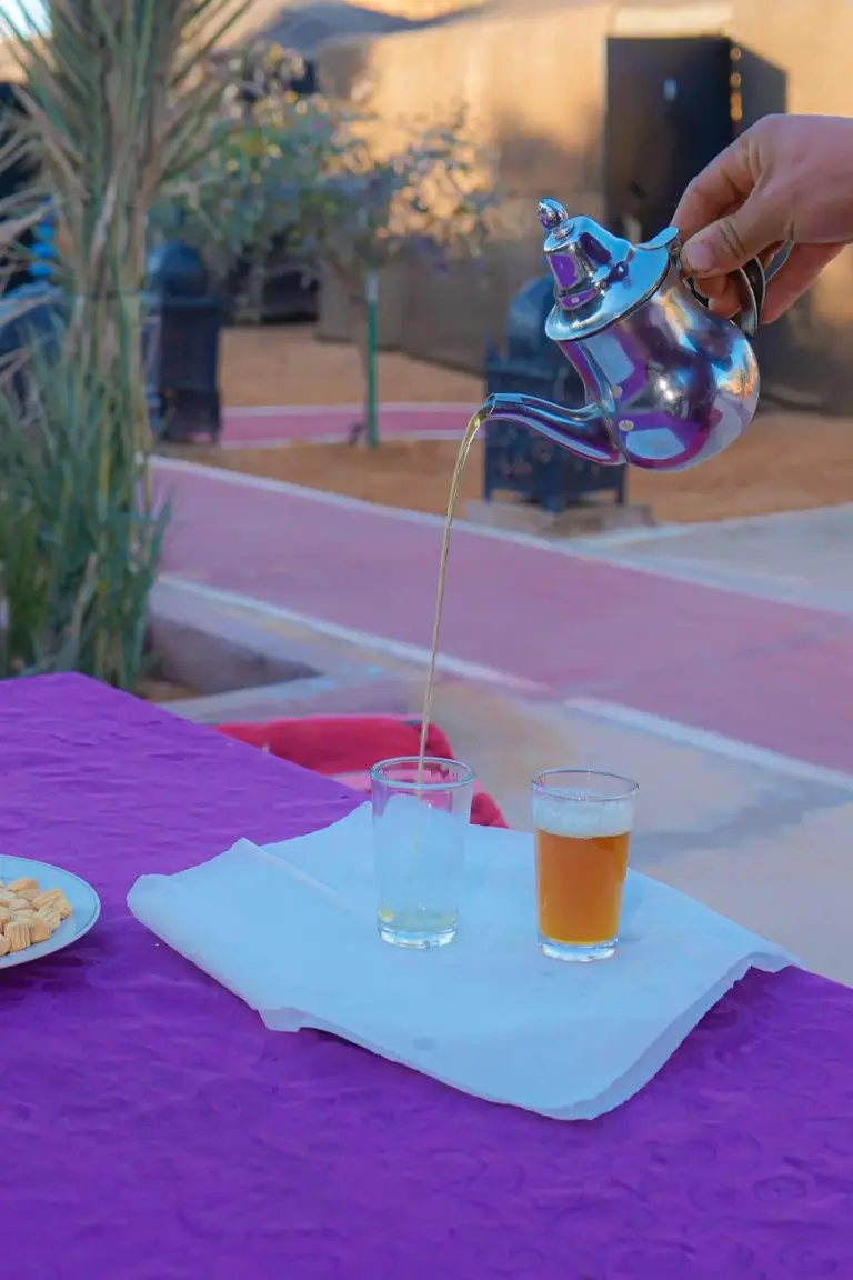 Mustapha Camp Merzouga serviert traditionellen marokkanischen Tee am Tisch des Wüstencamps