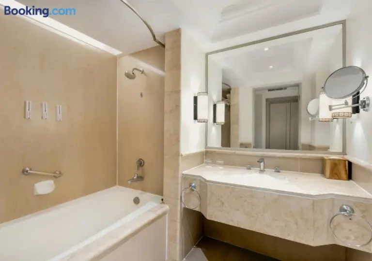 Salle de bains au Mustika Yogyakarta Resort and Spa avec une baignoire, un meuble vasque et un grand miroir.