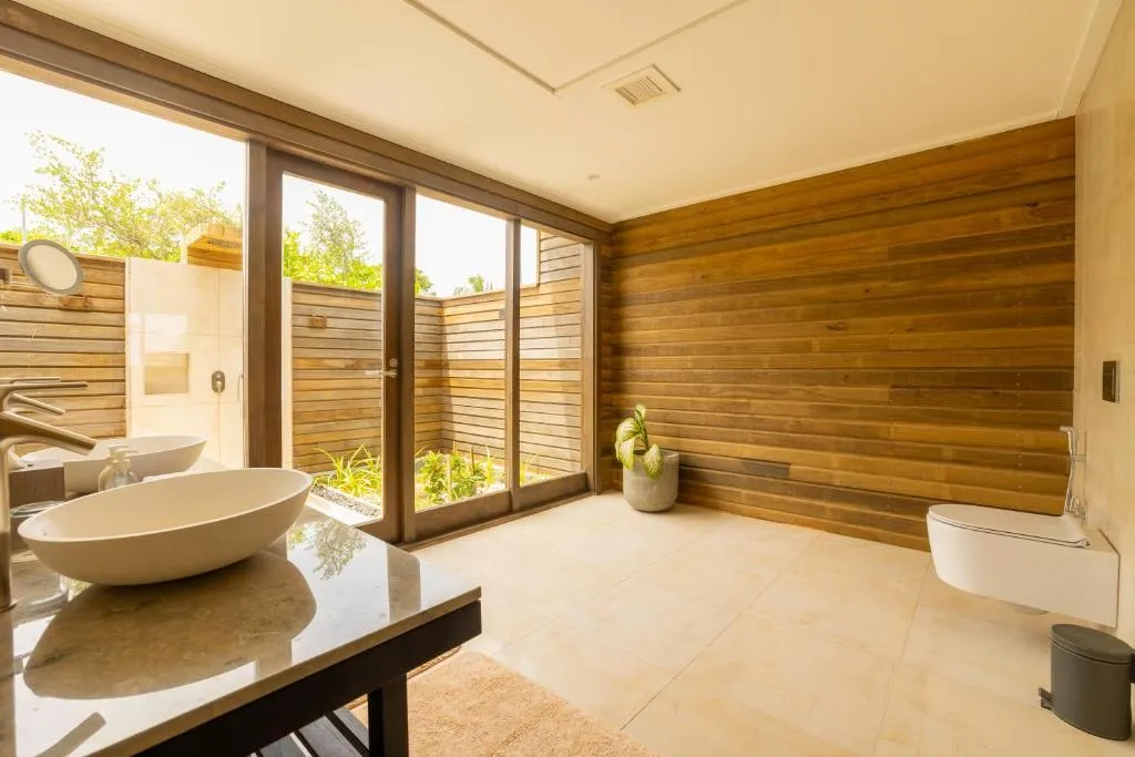Private bathroom space at Nala Maldives with natural light.