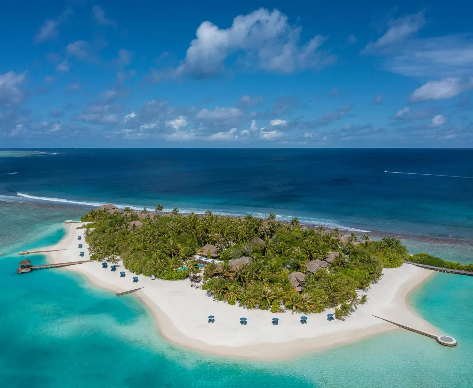 Vue aérienne de Naladhu Private Island Maldives montrant la plage immaculée et la végétation luxuriante.
