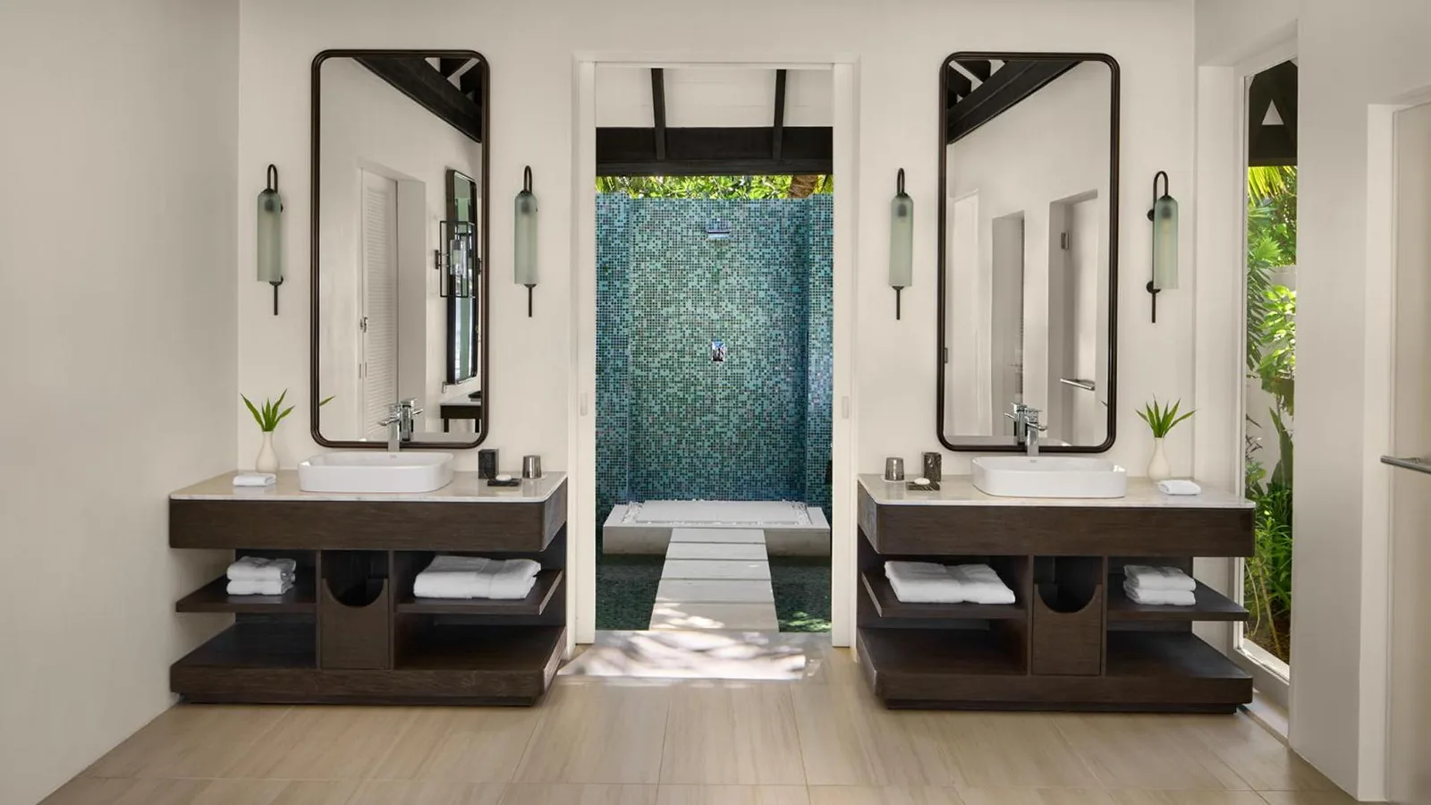 Salle de bain de luxe avec douche extérieure à Naladhu Private Island Maldives.