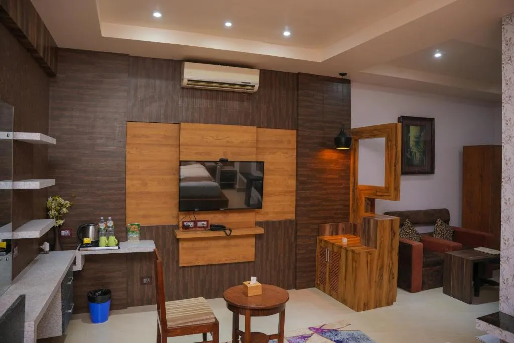 Nansc Hotel – Lumbini, Nepal hotel – una sala de estar con cocina y una sala de estar con un televisor en Nansc Hotel en Bhairāhawā