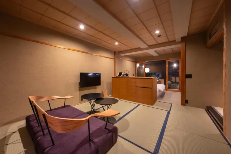 Nazuna Kyoto Nishi Honganji – hôtel à Kyoto, Japon – une chambre avec un canapé, deux chaises et une télévision à Nazuna Kyoto Nishi Honganji à Kyoto