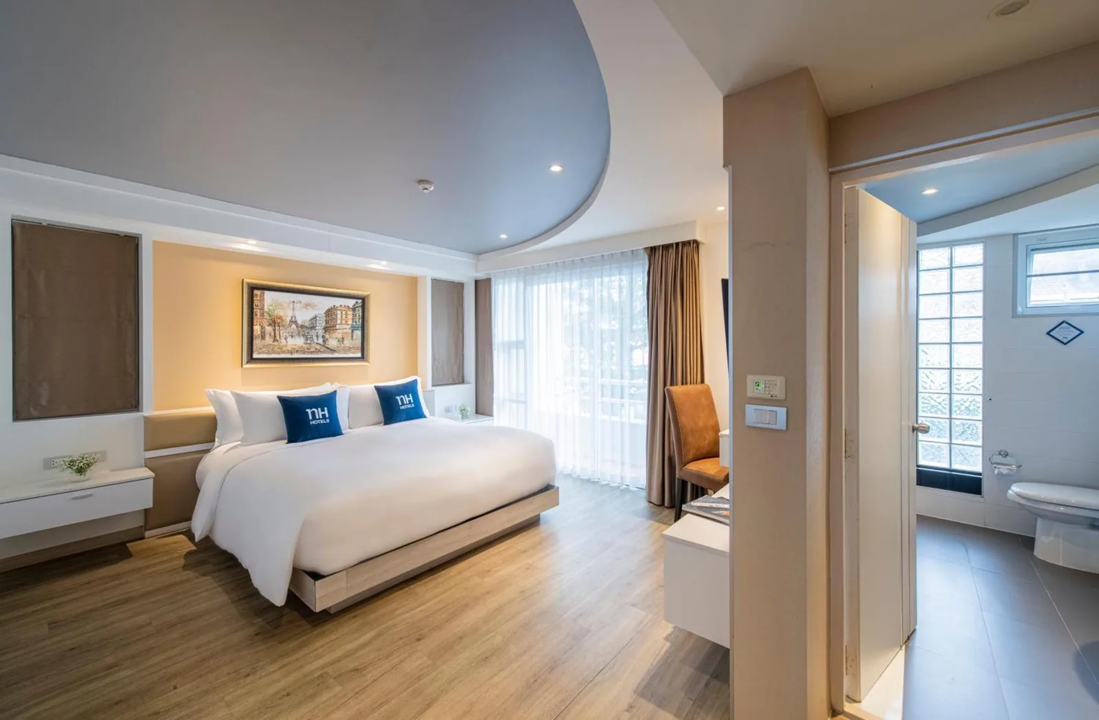 Guest room at NH Boat Lagoon Phuket Resort in Phuket with bedroom and visible bathroom entrance.