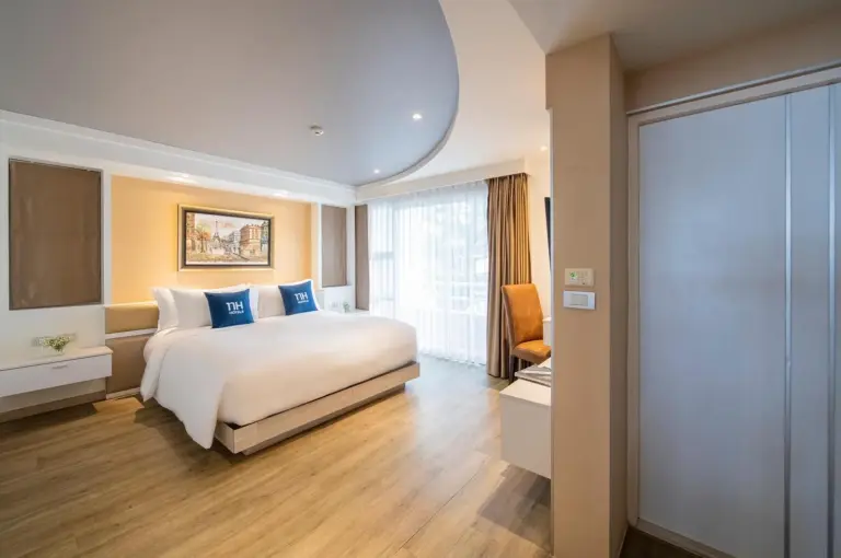 Spacious guest room at NH Boat Lagoon Phuket Resort in Phuket with king bed and modern furnishings.
