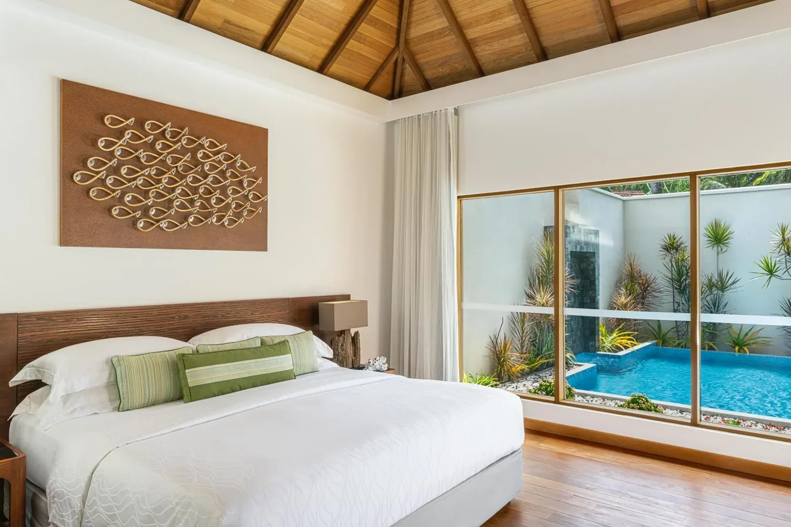 Niva Kurumba Maldives – hotel en Male, Maldives – un dormitorio con vistas a una piscina a través de una ventana en Niva Kurumba Maldives en Male City