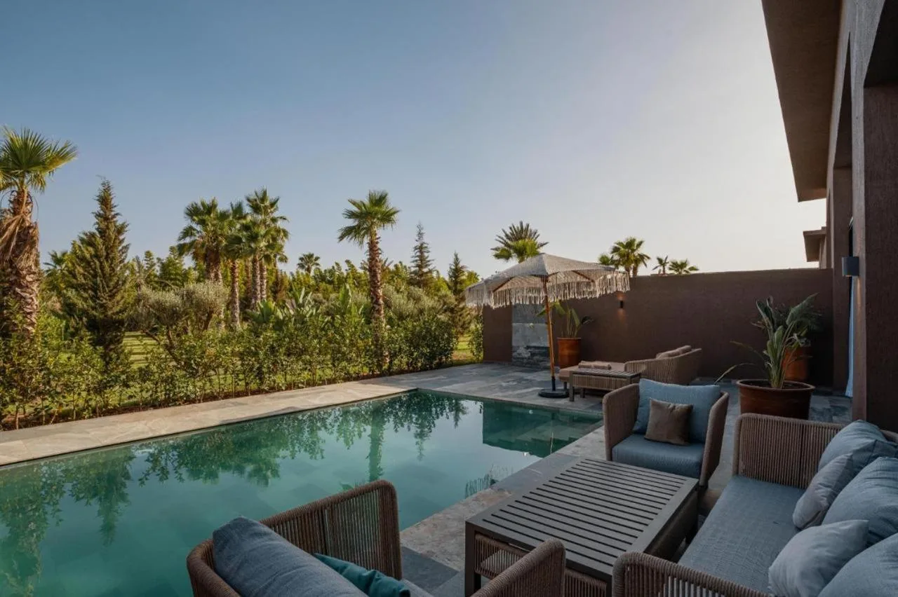 NOMMOS Beach RESORT & POOL CLUB – Hotel in Marrakesch, Marokko – ein Swimmingpool mit Stühlen, einem Sofa und einem Tisch im NOMMOS Beach RESORT & POOL CLUB in Marrakesch