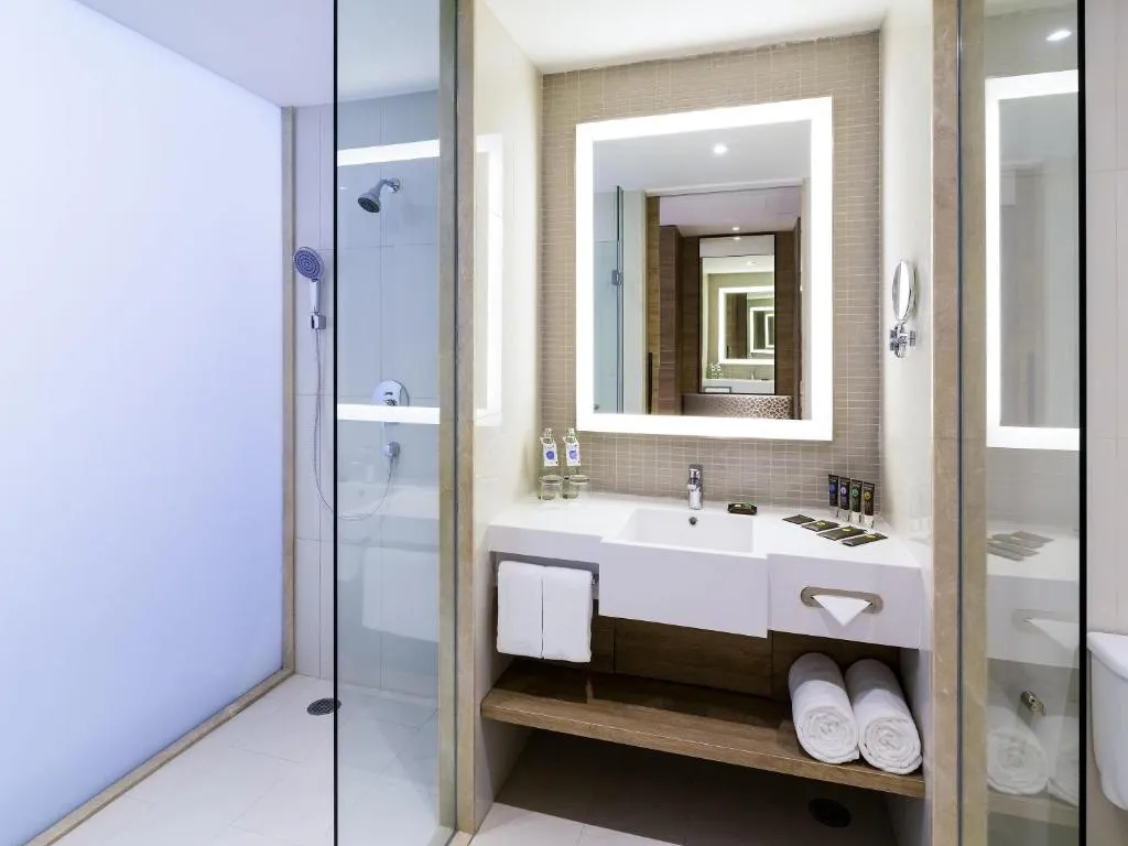 Novotel Phuket City Phokeethra – Phuket, Thailand hotel – a bathroom with a sink and a toilet and a mirror at Novotel Phuket City Phokeethra in Phuket Town