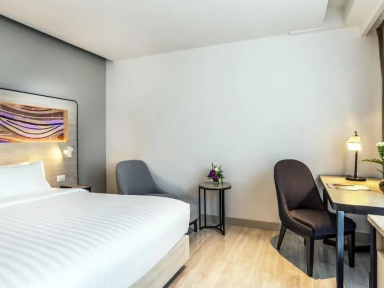 Novotel Phuket City Phokeethra – Phuket, Thailand hotel – a bedroom with a bed and a desk and chairs at Novotel Phuket City Phokeethra in Phuket Town