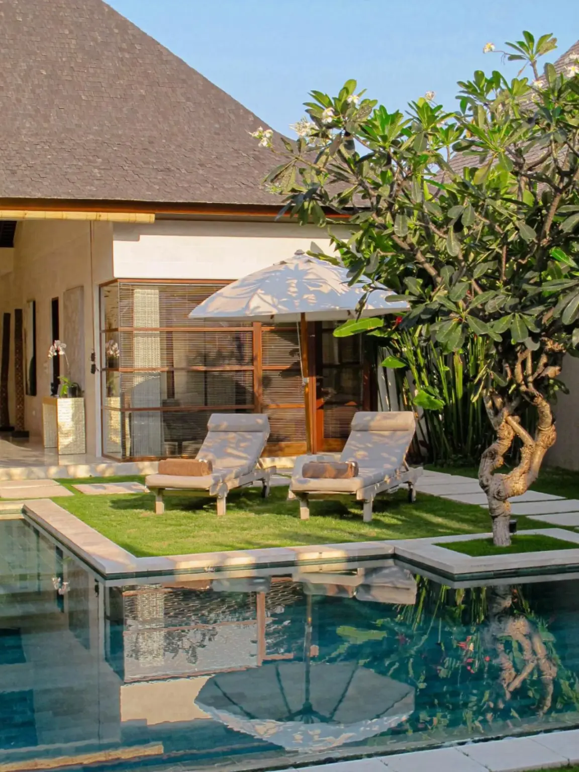 Lounge chairs by the pool at Nyaman Villas Seminyak