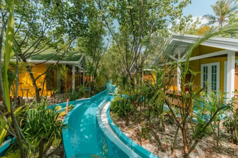 Poolvillen inmitten üppiger Vegetation im Oaga Art Resort Maldives