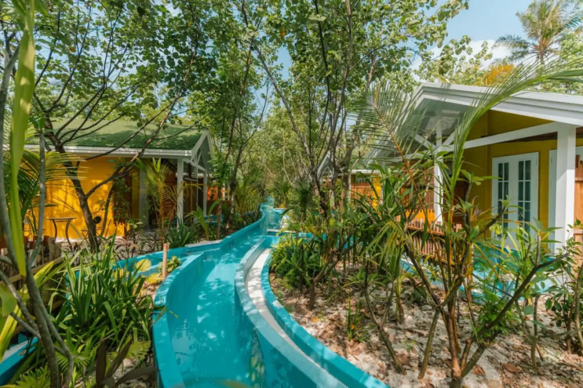 Poolvillen inmitten üppiger Vegetation im Oaga Art Resort Maldives