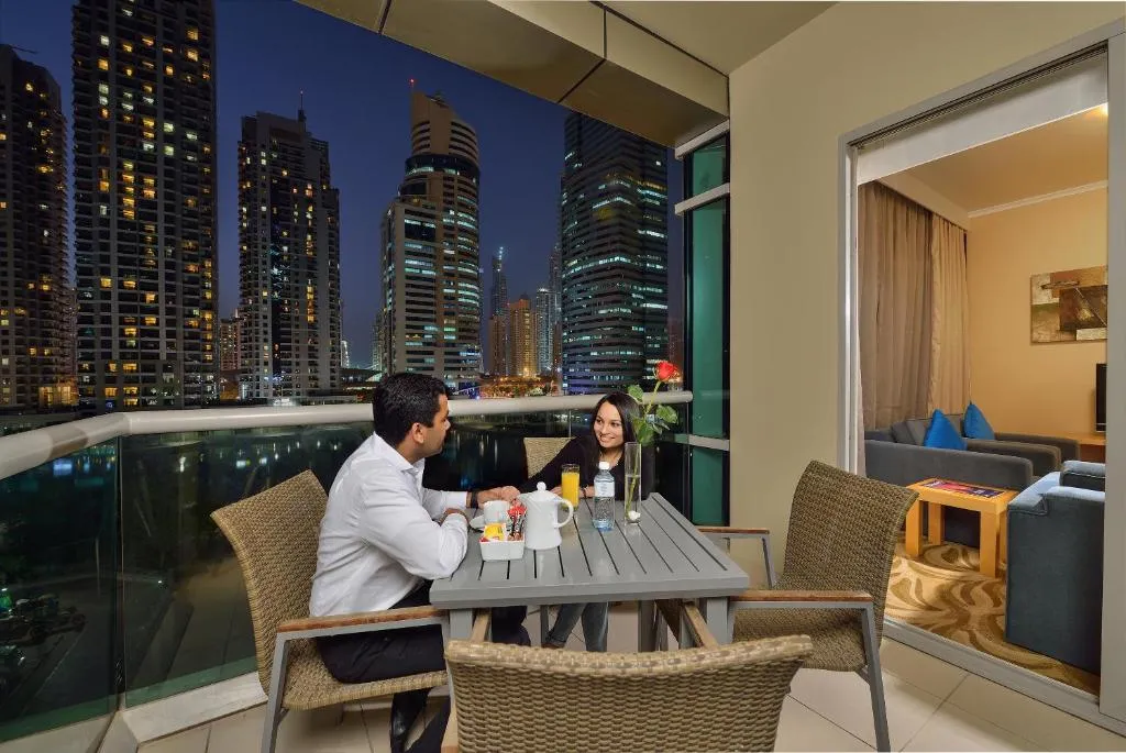 Paar beim Essen auf dem Balkon im Oaks Liwa Heights Hotel Suites