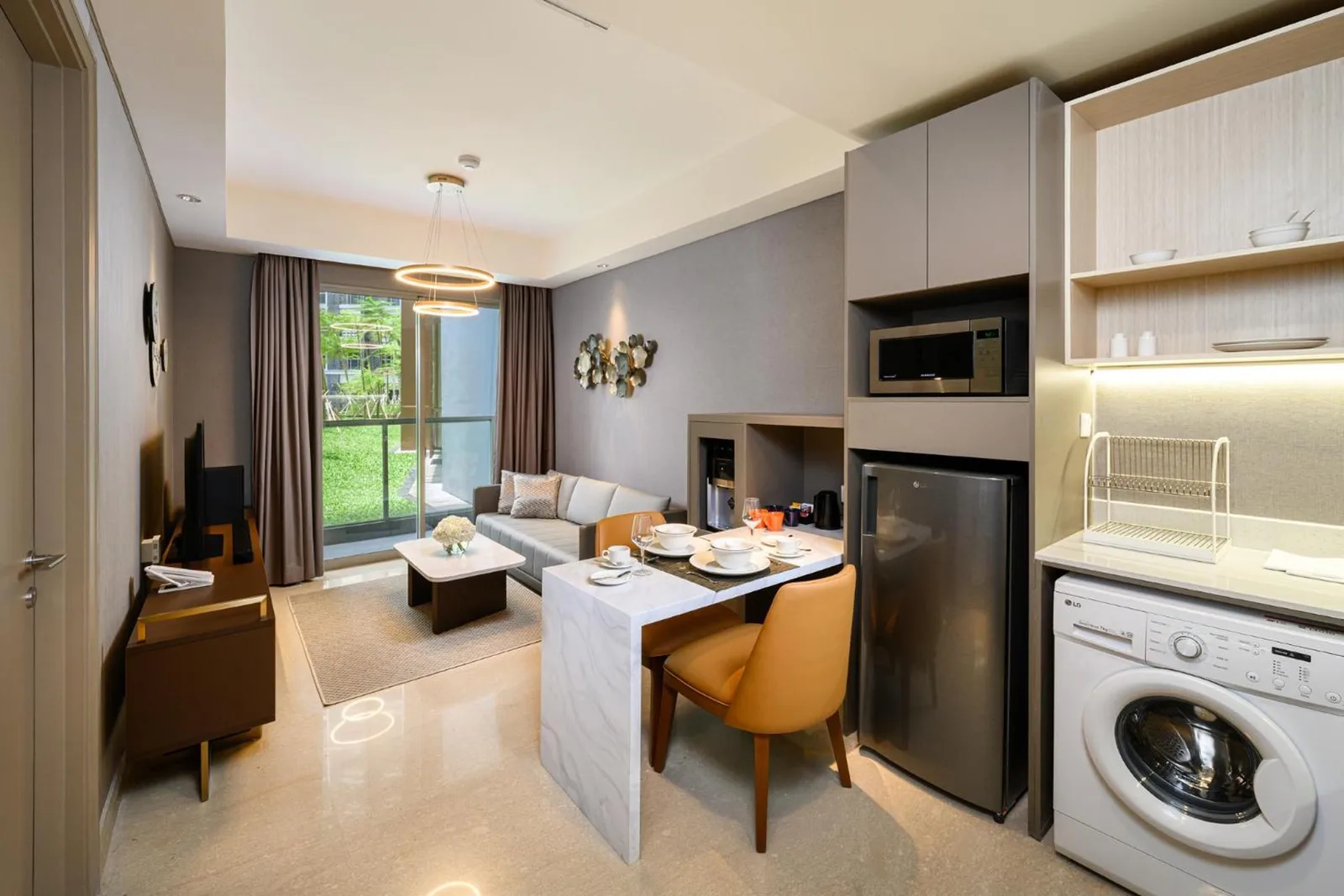 Zona de salón en el apartamento de Oakwood PIK Jakarta con espacio para comer.