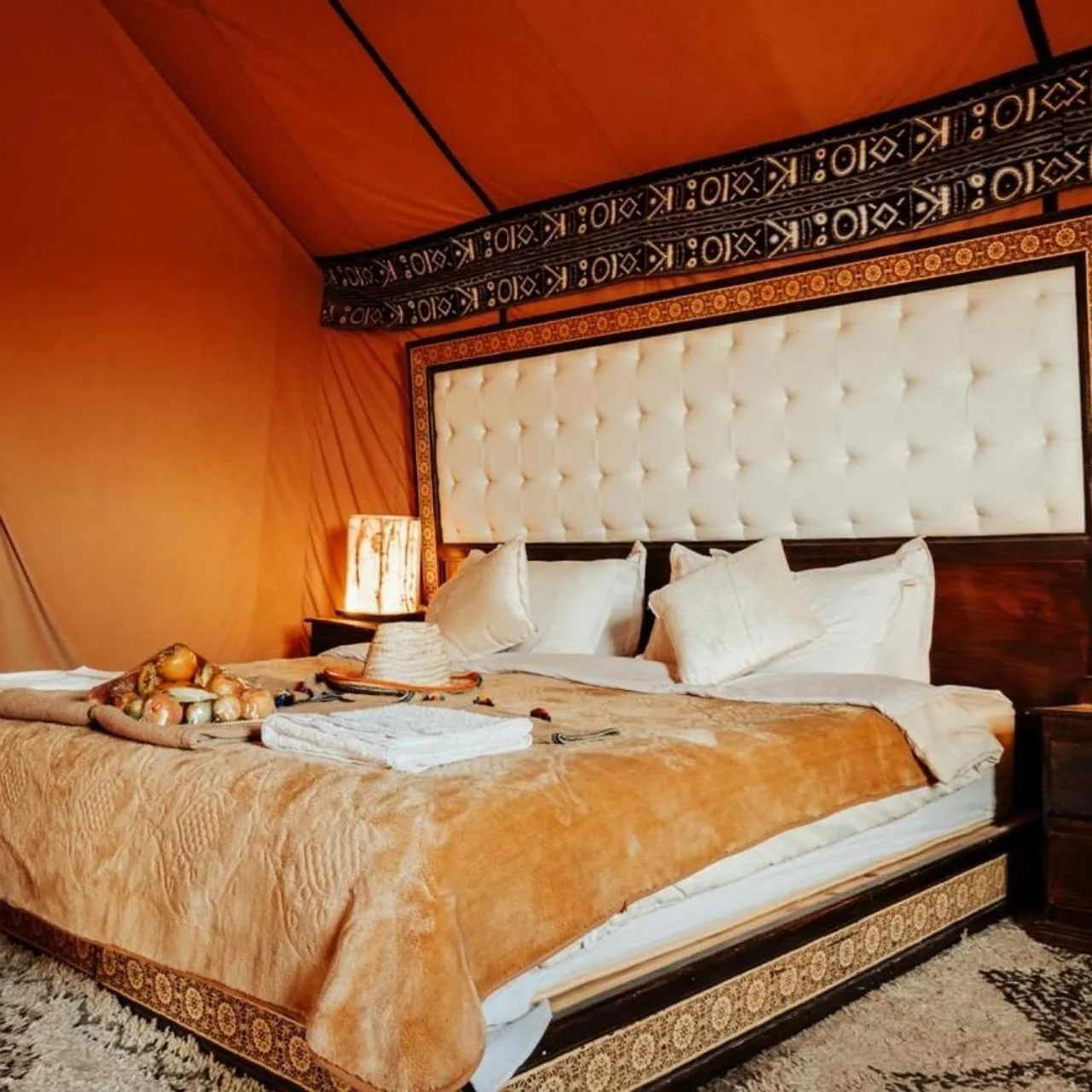 Lujosa cama y montaje de comedor en Oasis Mirage Luxury Camp en Merzouga