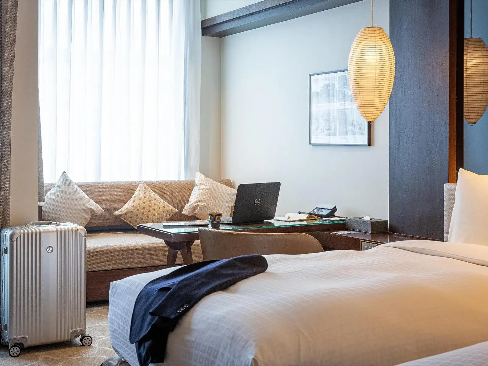 Okinawa EXES Naha room with laptop and suitcase