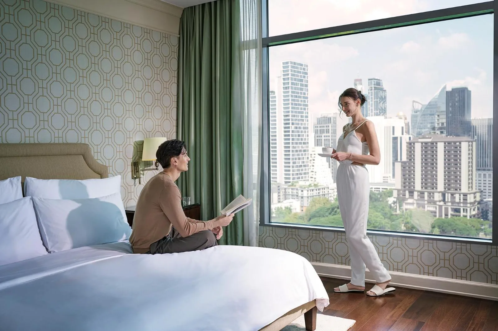 Guest reading in bedroom at Oriental Residence Bangkok