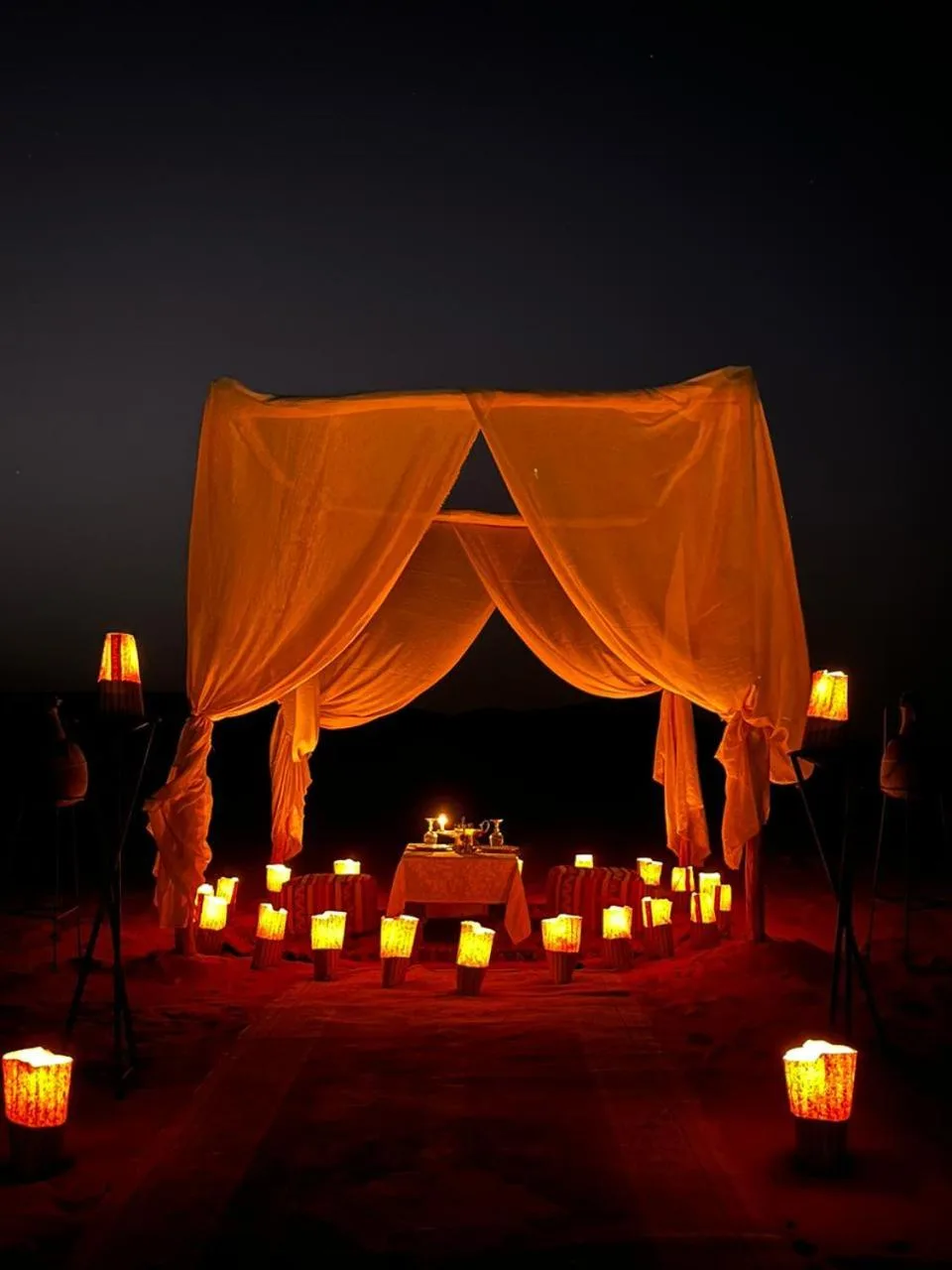 Romantic candlelit setup at Original Luxury Camp in Merzouga under a desert canopy