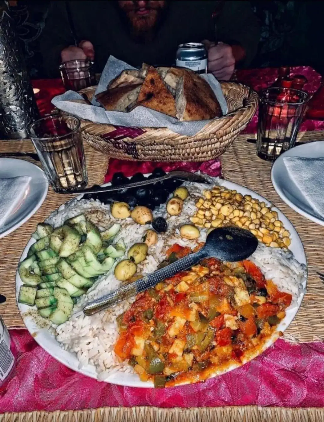 Un dîner traditionnel servi à Overnight Desert Camp à Merzouga avec pain, riz, légumes et boissons.