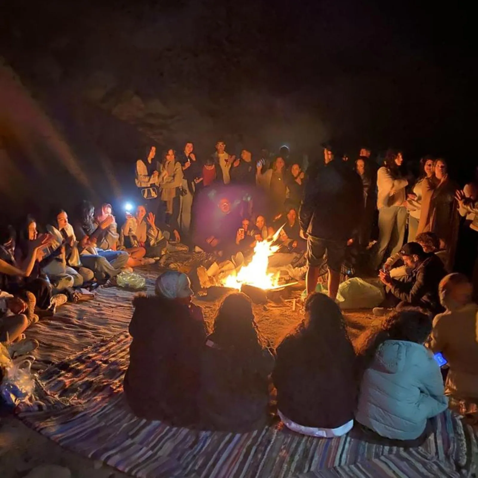Celebración nocturna alrededor del fuego en Overnight Luxury Camp en Merzouga