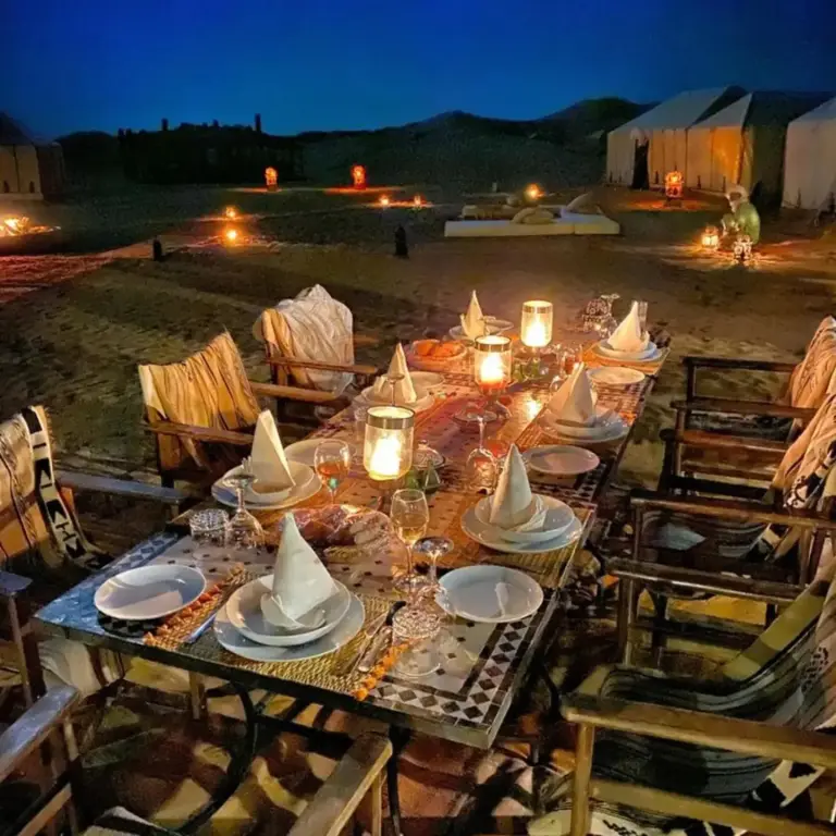 Montaje de comedor al aire libre en Overnight Luxury Camp en Merzouga bajo las luces