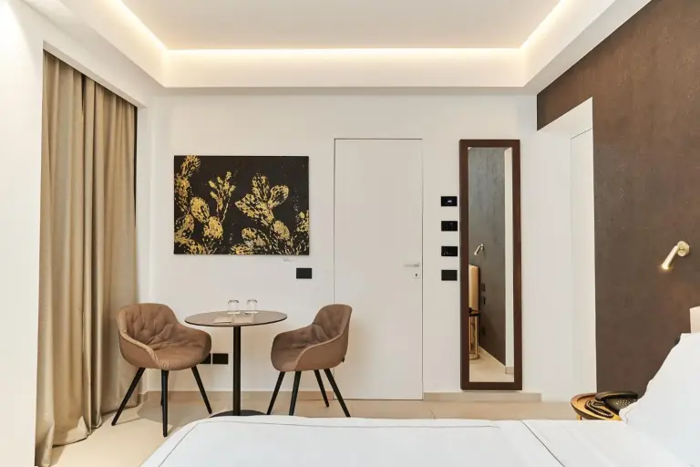 Palazzo Salomone – Syracuse, Italie hôtel – une chambre avec un lit et une table et deux chaises au Palazzo Salomone à Siracusa