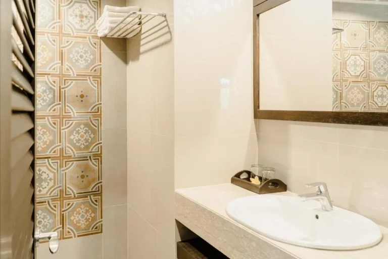Interior de baño moderno en Palm Beach Hotel Bali con azulejos elegantes.