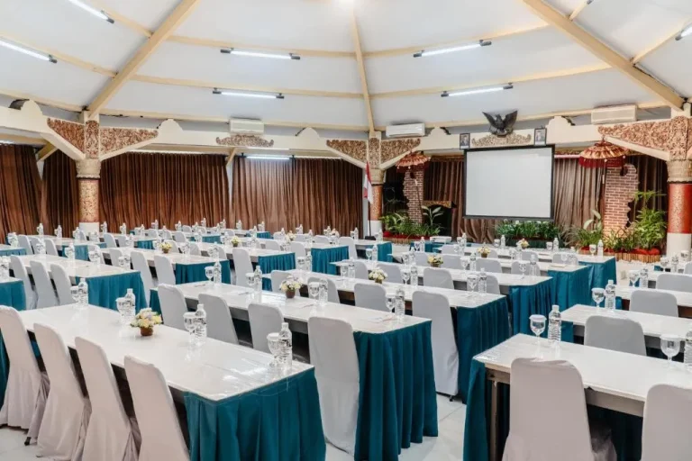 Configuración de la sala de conferencias en Palm Beach Hotel Bali con mesas y equipo.
