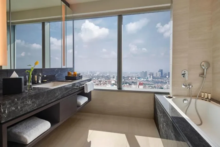 Baño elegante con vistas a la ciudad en PARKROYAL Serviced Suites Jakarta