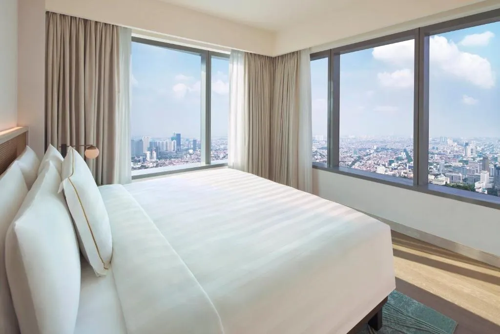 Inviting bedroom with panoramic views at PARKROYAL Serviced Suites Jakarta
