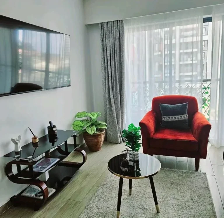 Salon des Pinnacle Suites Nairobi avec un fauteuil rouge