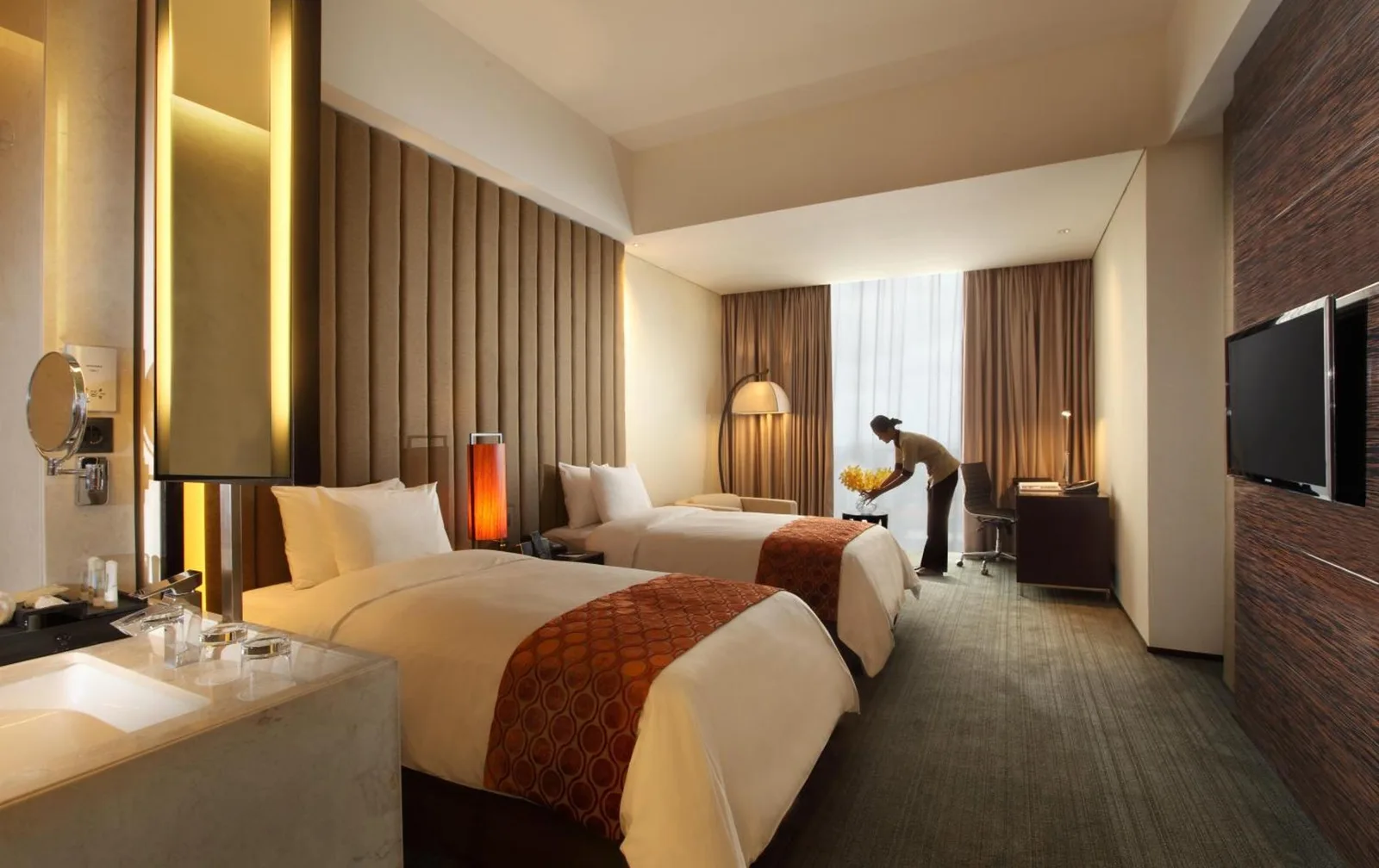 Amplia habitación de huéspedes en PO Hotel Semarang en Semarang con cama king, sillón y gran ventana.
