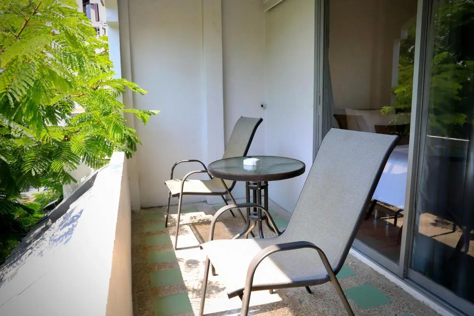 Balcon privé de Pooh Beach Resort & Spa à Pattaya avec fauteuils et petite table
