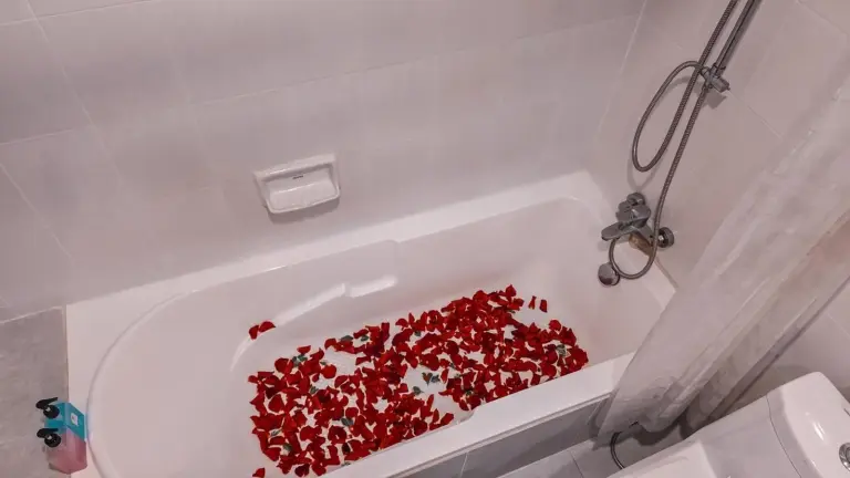 Baignoire de Pooh Beach Resort & Spa à Pattaya décorée de pétales de rose rouges pour un séjour romantique
