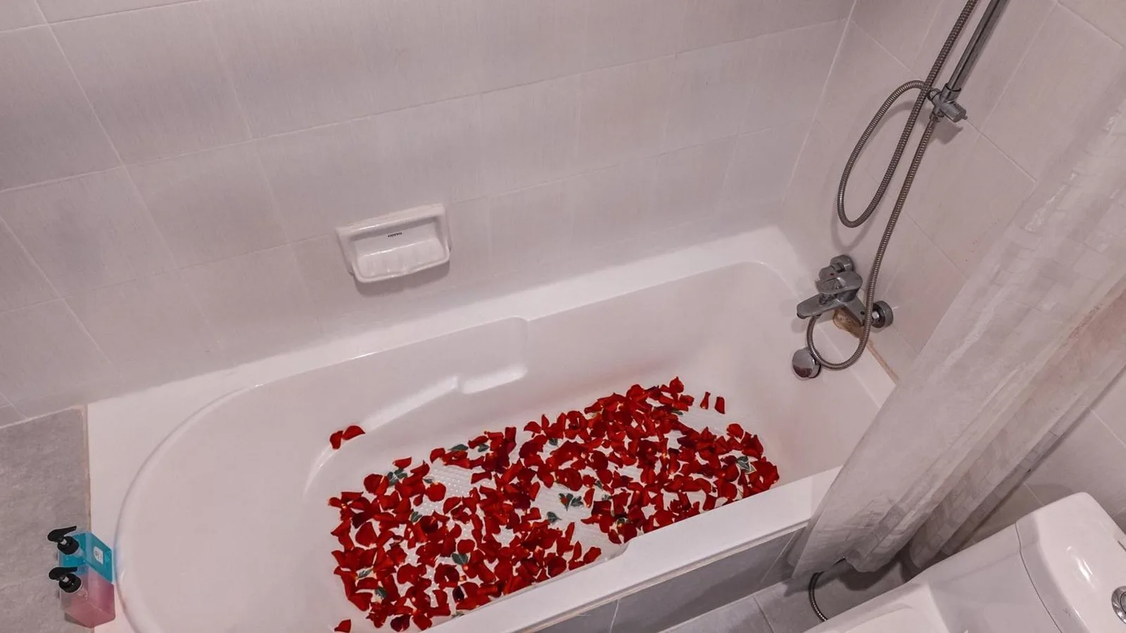 Baignoire de Pooh Beach Resort & Spa à Pattaya décorée de pétales de rose rouges pour un séjour romantique