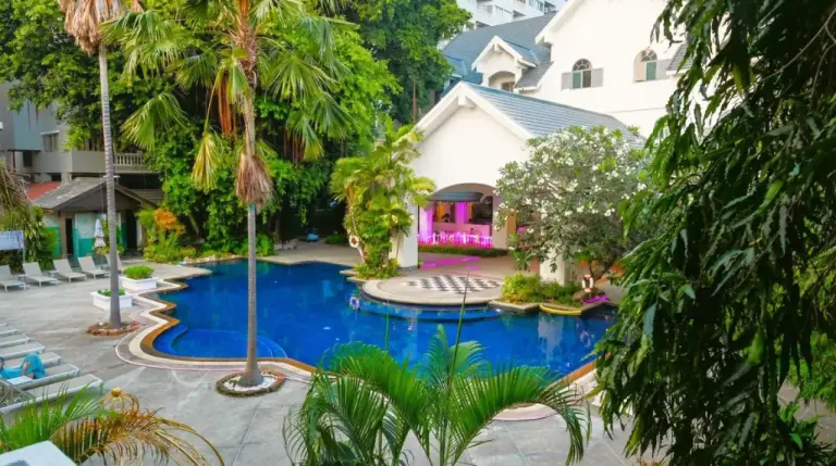 Piscine extérieure de Pooh Beach Resort & Spa à Pattaya, entourée d’une végétation tropicale et des bâtiments du resort