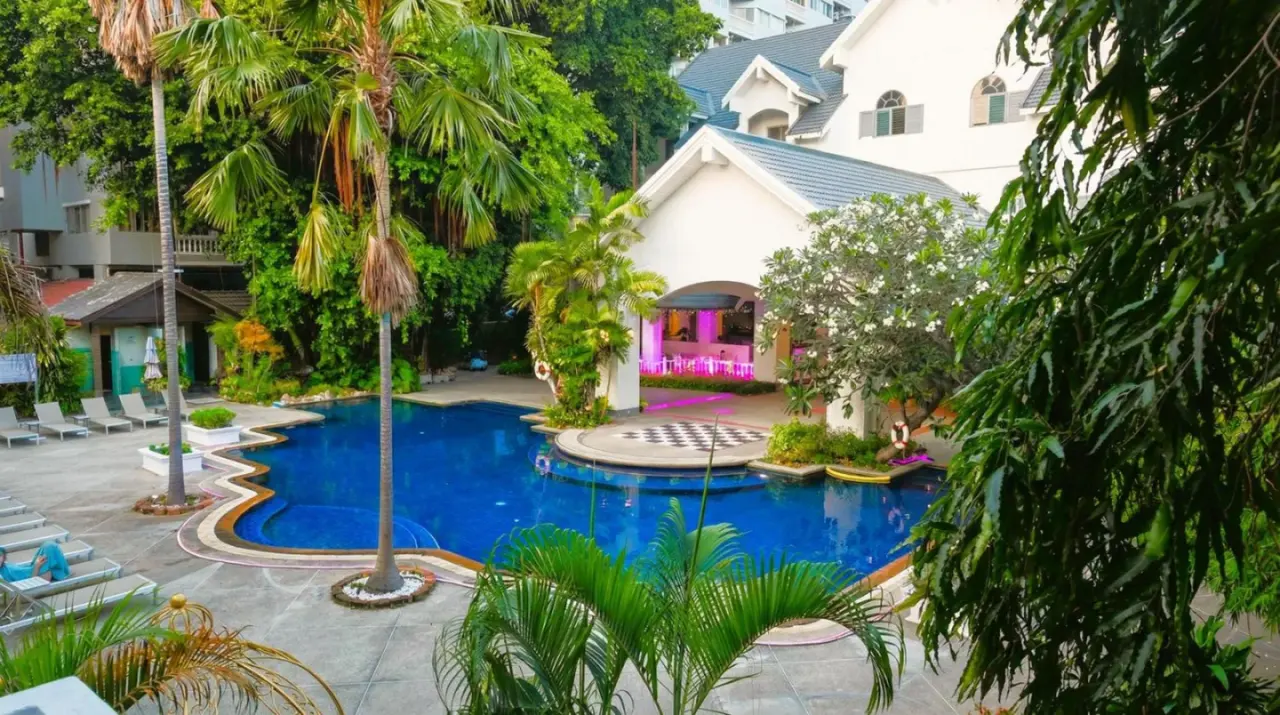 Piscine extérieure de Pooh Beach Resort & Spa à Pattaya, entourée d’une végétation tropicale et des bâtiments du resort