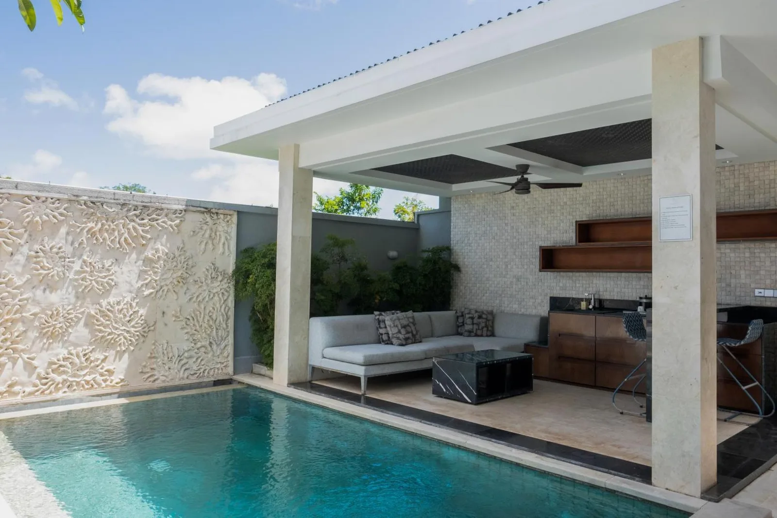 Zona de descanso junto a la piscina en Prasana Villas Uluwatu